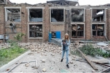 Razboi in Ucraina. Tânără în fața unei clădiri avariate în Kiev 